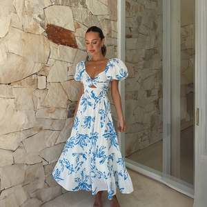 Detail of puff sleeves and waist cut-out on a white floral V-neck maxi dress