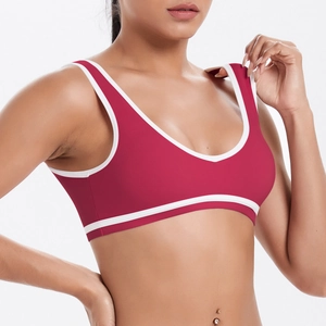 Detail of red sports bra with white contrast piping and breathable stretch fabric