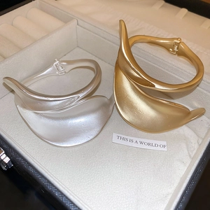 Close-up of gold and silver matte irregular fluid metal bangles in a jewelry box