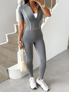 Detail eines grauen Y2K-Sportsets mit Kurzarm-Oberteil und High-Waist-Leggings