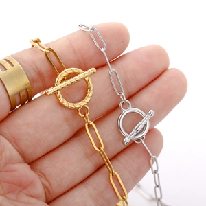 Detailed macro view of 18k gold and silver OT toggle clasps on paperclip chain jewelry