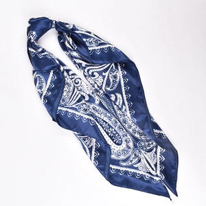 Detailed view of dark blue paisley satin scarf showing smooth texture and edge stitching