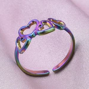 Macro shot of rainbow gradient heart-shaped adjustable ring on pink silk fabric