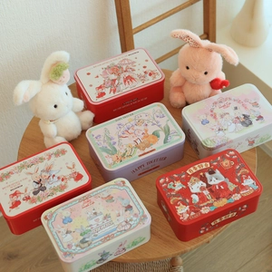 Assorted Christmas rabbit illustration tin boxes for candy gifts and storage on wooden table