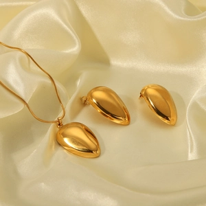 Polished 18k gold plated stainless steel teardrop necklace and stud earrings set on silk