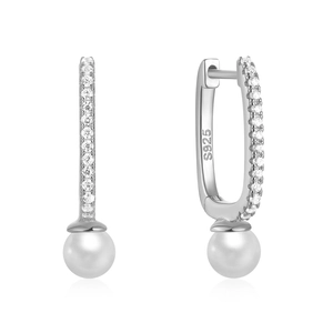 Macro shot of S925 sterling silver earrings with zircons and hanging round white pearls