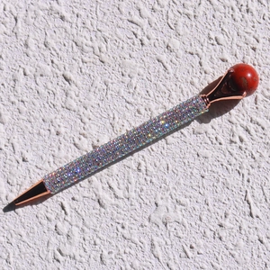 Detailed close-up of a colorful rhinestone ballpoint pen with rose gold metal accents
