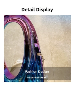Detail of blue-purple iridescent acrylic clutch with round handle and gold chain