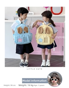 Detailed view of plush dog ears and star patch on a light blue kids backpack