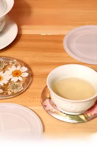 Food-grade silicone mold for DIY resin coasters featuring dried daisy flower designs