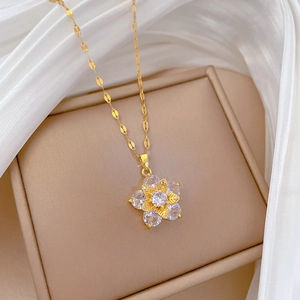 Macro shot of gold five-leaf flower necklace with sparkling crystal inlay on silk