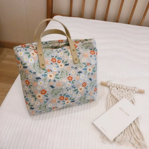 Vintage floral canvas tote bag in light blue with daisy prints and leather handles