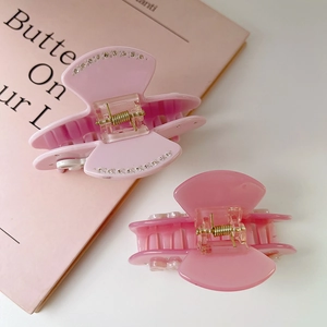 Detail of pink bow hair clips with rhinestones and gold metal springs on book
