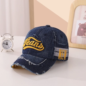 Détail de la casquette en denim vieilli avec broderie Jeans jaune et bord effiloché