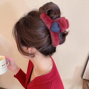 Winter burgundy faux fur hair claw clip featuring a dark blue heart detail worn by a model