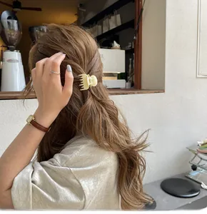 Molla per capelli giallo crema su modella in un caffè con un'atmosfera elegante