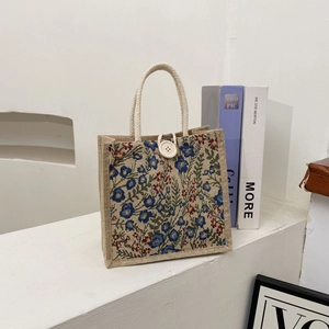 Close-up of floral jute tote bag with button closure and blue flower patterns