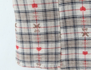 Close-up of plaid fabric with embroidered hearts and bears on a vintage shirt