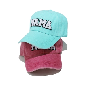 Detail of washed cotton baseball caps with MAMA towel embroidery in blue and red