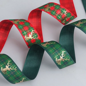 Detail of red and green plaid Christmas ribbon with gold elk print and ribbed texture
