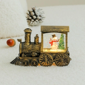 Macro view of vintage bronze Christmas train lantern with glowing snowman and glitter