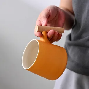 Minimalist ginger yellow matte ceramic mug featuring a cylindrical wooden handle design