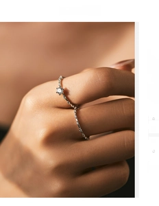 Close-up of a wavy S925 silver ring with moissanite diamonds worn on a finger