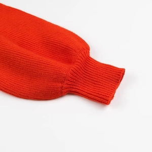 Dettaglio della trama in maglia a coste e dei polsini su questo maglione rosso moda