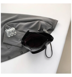 Detailed internal view of jacquard bucket bag showing zipper pocket and maroon lining