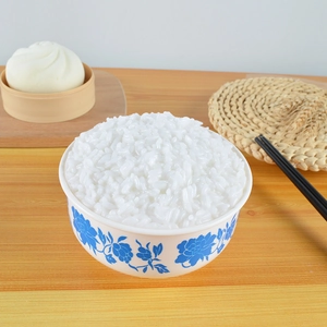 Macro shot of realistic white rice food model in a blue floral pattern ceramic bowl