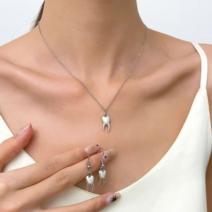 Dames sieradenset van zilverkleurig metaal met unieke tandvormige ketting en oorbellen