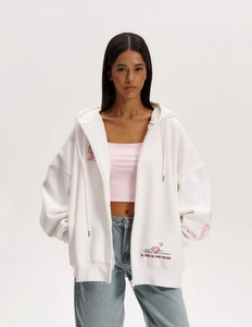 Dettaglio felpa bianca Y2K con zip, ricamo rosa e morbida consistenza in cotone