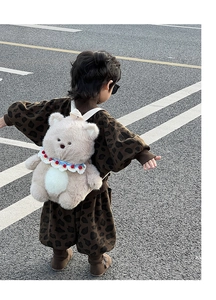 Close-up of fluffy bear plush backpack for toddlers with colorful knitted scarf detail