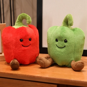 Cute plush bell pepper dolls in red and green with embroidered faces on wooden surface