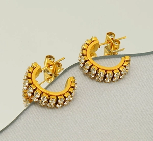 Vue détaillée des boucles d'oreilles dorées en C avec double rangée de zircons sertis