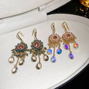 Macro view of floral tassel earrings with colorful crystals in a jewelry box