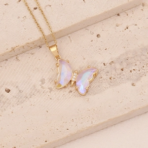 Détail macro du pendentif papillon en verre irisé avec plaquage or et zircons