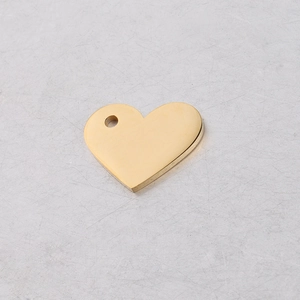 Detail of a gold hollow heart pendant with a pre-drilled hole for DIY jewelry making