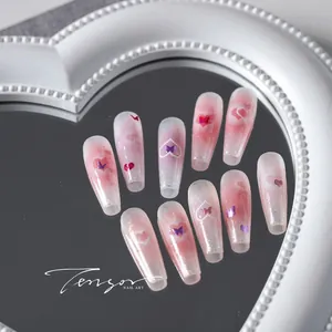 Macro view of long coffin press-on nails with pink gradient, pearls and butterfly sequins