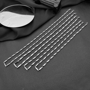 Ensemble de colliers en acier inoxydable argenté avec maillons losanges sur fond noir