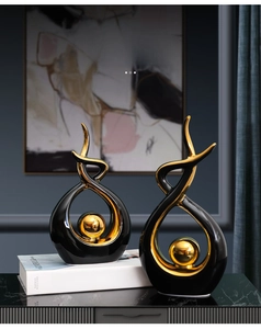 Close-up of modern black and gold abstract sculptures with polished gold spheres in the center