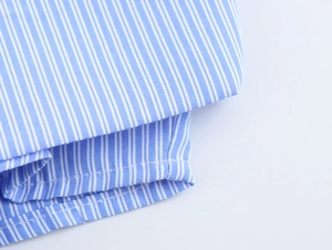 Close-up of blue and white striped shirt fabric texture and professional stitching details