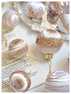 Detailansicht von Seidensatin-Weihnachtskugeln mit Goldglitzer und Pailletten auf einem Tablett