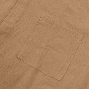 Detail of linen texture and buttoned chest pocket on a brown men's beach shirt