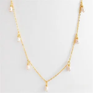 Close-up of 18k gold plated necklace with seven elegant white teardrop pearl pendants