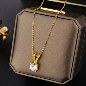 Gold titanium steel necklace featuring a V-shaped pendant with zircons on a jewelry box