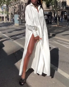 Détail d'une robe chemise blanche à manches longues avec une fente latérale profonde