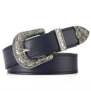 Detail of dark blue leather belt featuring ornate silver vintage western buckle and tip