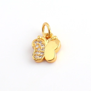 Detailed view of a gold butterfly pendant with one side featuring clear cubic zirconia pavé