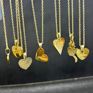 Detailed close-up of golden titanium heart necklaces with Mom and Love engravings